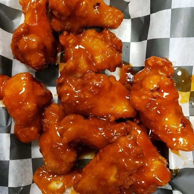 Close-up of Grandma Bair's sweet and sour chicken wings in a checkered paper-lined basket.